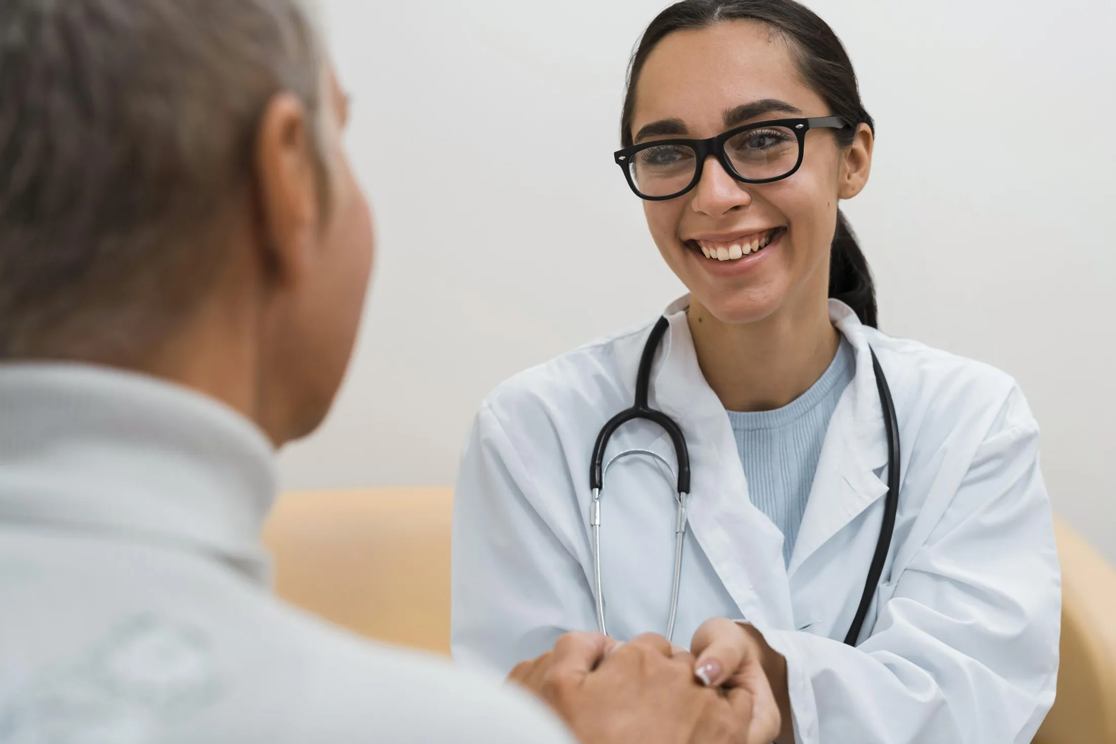 Médica sorridente conversando com paciente durante consulta